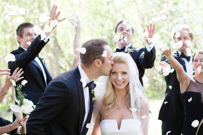 Elegant white wedding | bride & groom at Gardener Ranch, Carmel Valley | Bridal party showering couple with rose petals | Buena Lane Wedding Photography