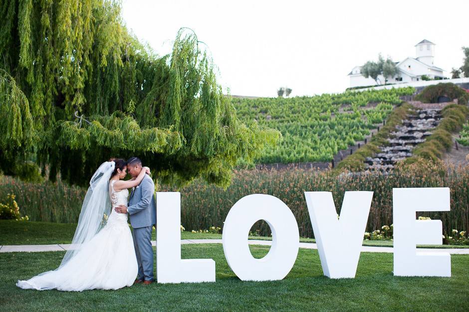 Bride and Groom with LOVE sign at Leal Vineyards | Hollister Wedding |  Buena Lane Wedding Photography