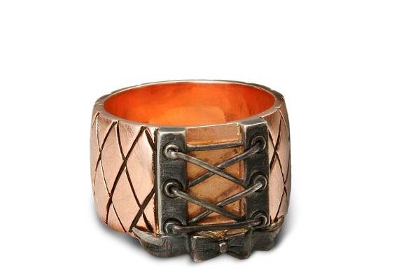 Looks like you “laced me up around my finger!” This 14K Rose gold (shown) band is reminiscent of fishnet or quilted fabric seen in corsets. The lace up part is detailed with a bow. Design continues all around to size bar in back. Wear it with your favorite corset when you go out on the town or with your favorite dress or just simply with jeans. Set in choices of 14K Rose, 14K White, or 14K Yellow gold with blackened detail in grooves and lace up part.
Made with Rose Gold, White Gold or Yellow Gold.