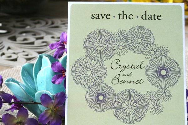 Modern rustic flowers in a circle are featured in this save the date card