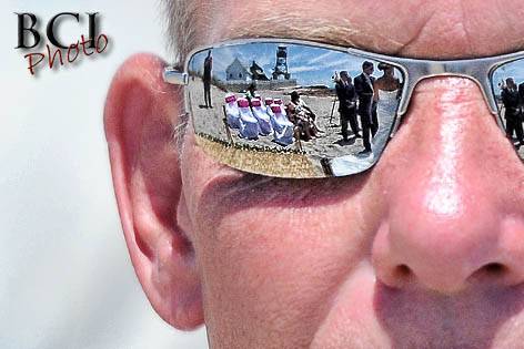 The reflection of the wedding ceremony as seen in this proud fathers sunglasses for this beach wedding in Florida