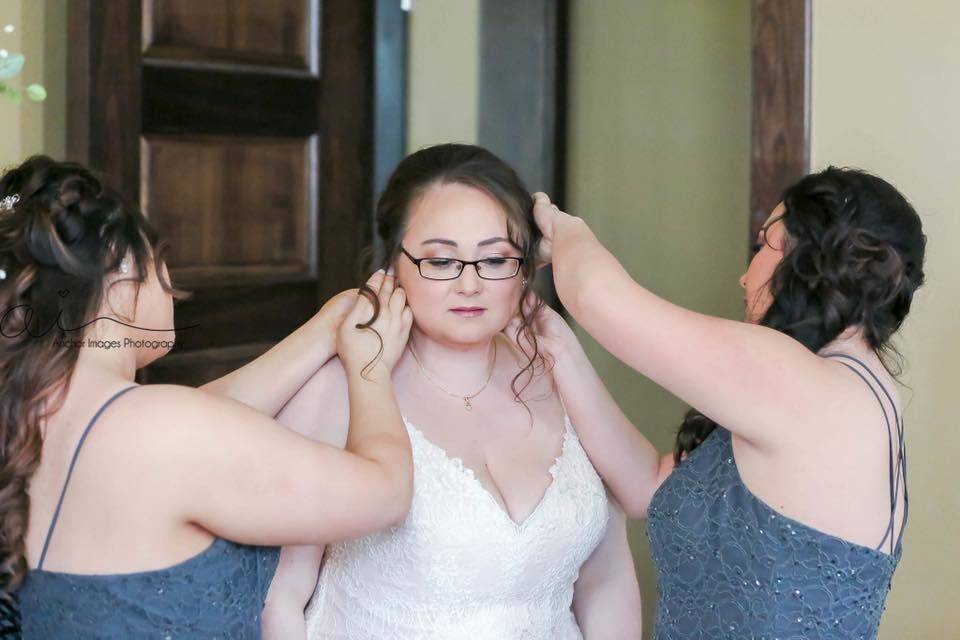 Bride assisted with her accessories and hair
