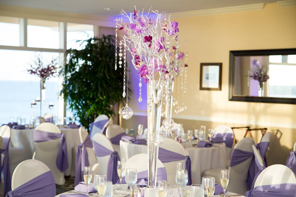 Purple chair bands and raised floral centerpiece
