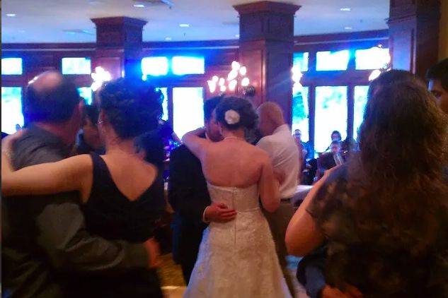 Guests and newlyweds slow dancing