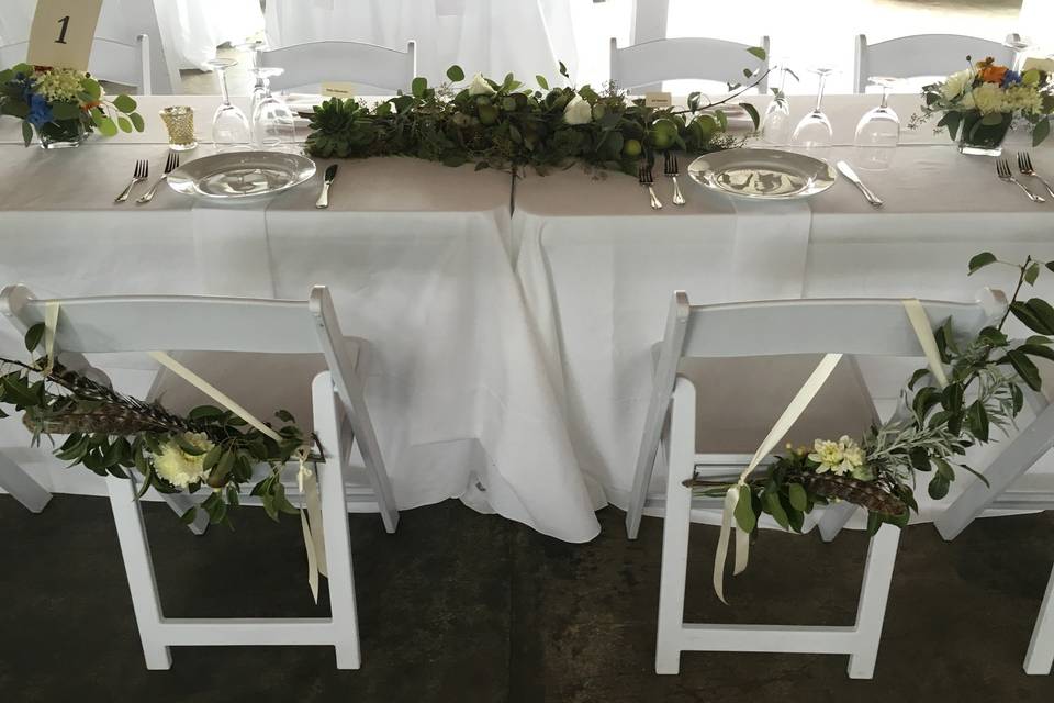 Feather and florals on head table chairs