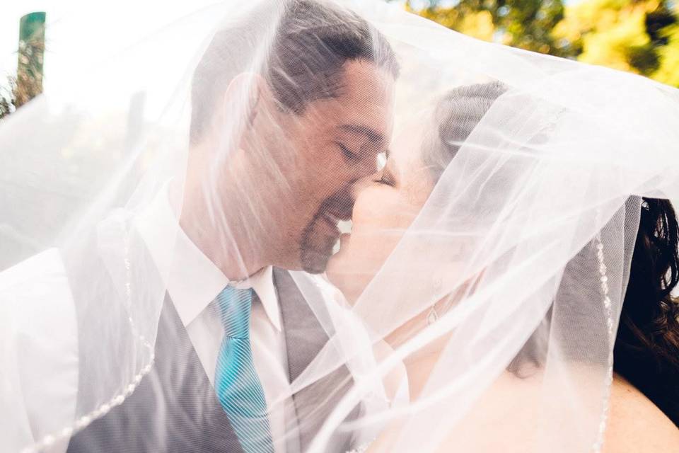 Kiss underneath bride's veil