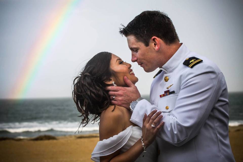 Couple kiss underneath a rainbow