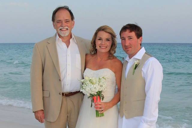 Officiant with the newlyweds at the beach