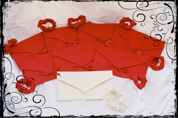 ENVELOPE CLUTCH BAGS-approx.6 x 9...shown here in ruby red matte satin & cream satin.  Each has matching embroidered initial and satin ribbon bow.
Fully lined.