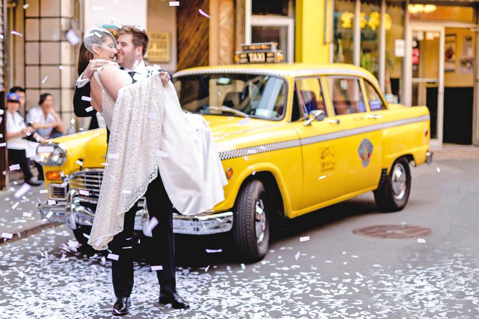 Couple pose in front of a taxi
