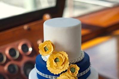White and blue wedding cake with yellow flowers