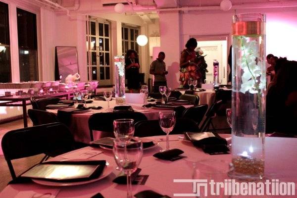 Close up on illuminated table decor featuring Statuesque Events china and vases for an evening reception in a chic loft in midtown, NYC.