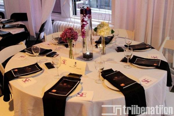 Modern purple and white themed table arrangement featuring Statuesque Events china and vases in a chic midtown loft