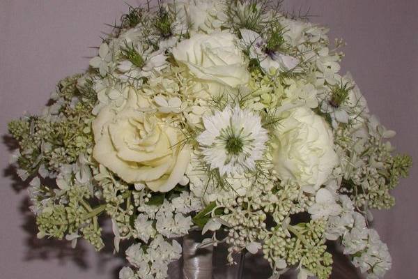 Ivory bridal bouquet featuring nigella, lisianthus, hydrangea, roses and statice.