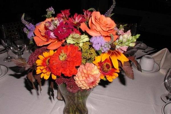 A bright fall wedding centerpiece graces the table.