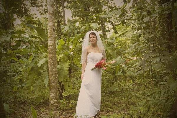 A bride wanders through the rainforest on the way to her ceremony on the Costa Rican beach.