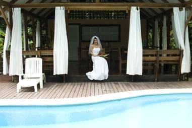 A bride sits by the pool at her lodge before her Costa Rica wedding.