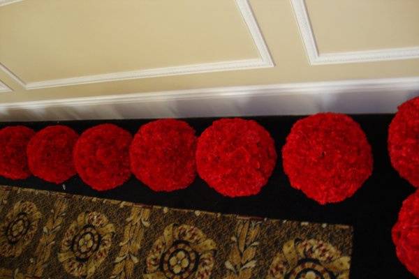 Balls of red carnations for centerpieces designed by Stein Your Florist Co.