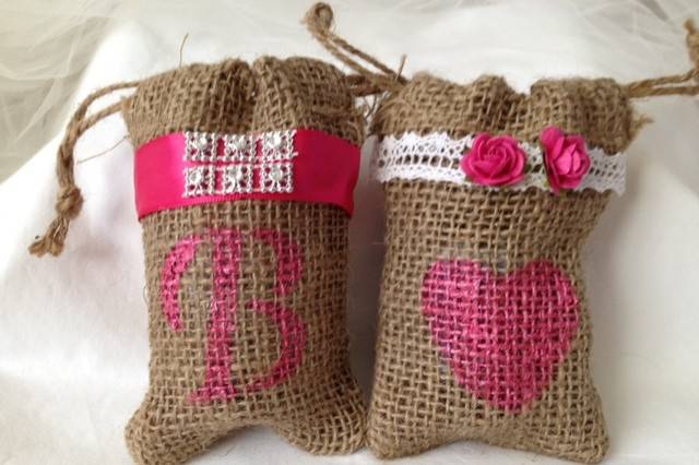 Perfectly rustic! These customized burlap bags have two functions! Not only do they hold your guests party favors they also add color and creativity to you table! Your guests will be amazed at the attention to detail. We are offering these bags in two styles: Country Bling (with hot pink ribbon and bling detail) or Pure Country (lace ribbon detail and matching roses).All the bags are 3-1/2'' x 5''. We can customize any bag to fit your needs. Your choice of lettering and color. Don't see a color that matches your decor? Send us an email and we will be happy to work with you on perfecting your bags.Set of 20 custom burlap bags for $50.00We also offer matching place card holders so please view our entire shop.Because we are working with burlap bags, there will be some slight irregular shapes.Keep your party rustic chic!Be sure to visit www.etsy.com/shop/tuttirosedesigns to see our entire collection.