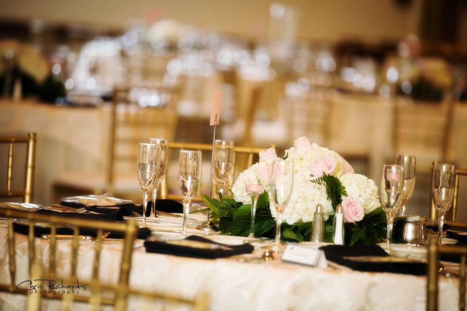Centerpieces were mostly ivory flowers with hints of blush. Surrounded by ivory and gold accents this centerpiece is classic elegance.