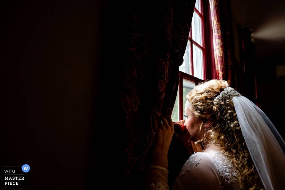 Bride looks out window