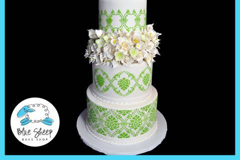 Four tiered white and green lace and floral wedding cake.