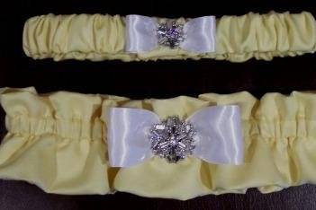 Butter yellow satin bridal and tossing garters with center tuxedo bow and rhinestone button