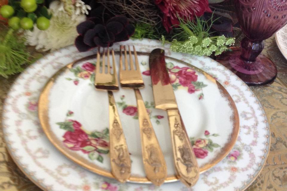 Glam vintage mismatched rentals in collection with gold flatware