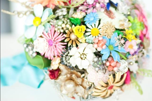 Family heirlooms and vintage pins add glamour and sentiment to this one-of-a-kind bridal bouquet -- available for rent from Vibrant Flowers.