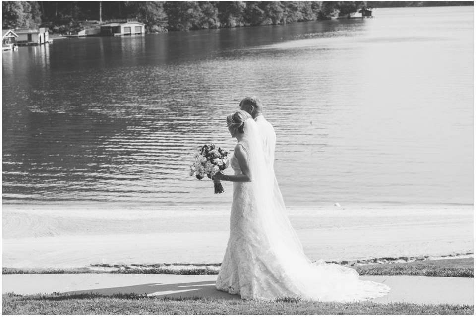 Bride and groom walk along the shore