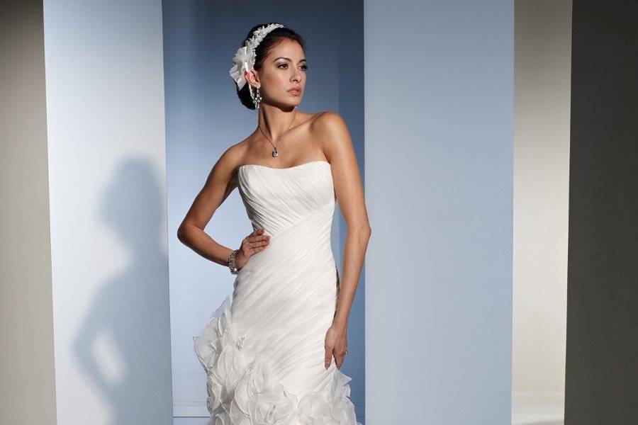 Y21158 - Luna <br>
Luna captures the essence of timeless elegance in Roma satin and misty tulle. The superbly draped sweetheart bodice is highlighted with lace appliqués, which continue into a single shoulder strap that asymmetrically spills across the back and features crystal beading. Adding a touch of drama the detachable tulle chapel length train is decorated with matching lace appliqués lightly dusted with hand-beading. The attached satin sweep train is caught by a beaded appliqué.