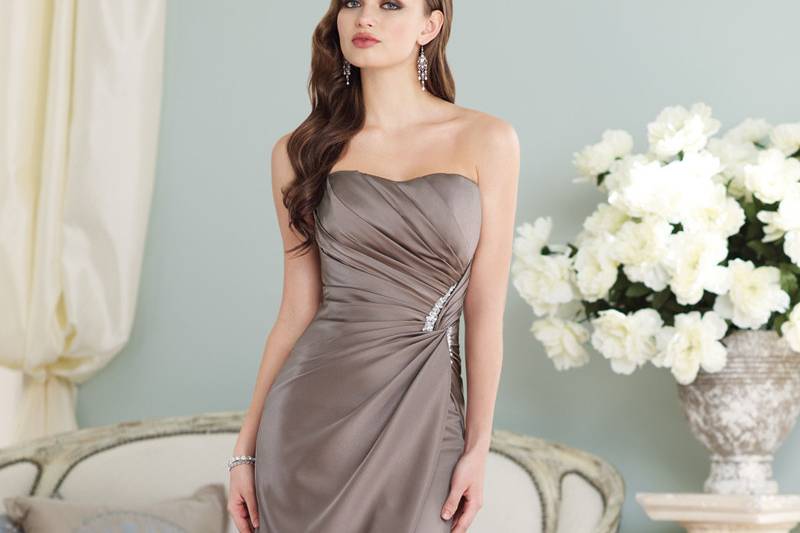 Style BY21392<br>
Strapless satin slim A-line gown with softly curved neckline, asymmetrically draped bodice features side twist trimmed with hand-beading, corset back, asymmetrical overlay skirt. Removable straps included. Available in all satin colors. Color shown: Stone
