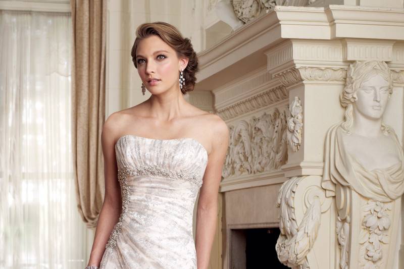 Style #y11403<br>
Stunning lace with pearl detailing signifies this chic slim A-line gown with front and back deep V-necklines. Brienne also offers lace and sheer tulle shoulder straps and a sparkling crystal brooch at the empire waist. A modern fairytale detachable chapel length train trimmed with matching scalloped lace accentuates the revealing sheer tulle and lace back bodice finished with a concealed back zipper and diamante buttons.