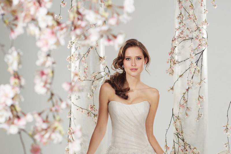 Style #Y11415<br>
Simultaneously angelic and sensual, slimming side draped lace A-line gown Roslin is simply elegant. Delicate hand-beading highlights the strapless sweetheart neckline while a matching beaded brooch adorns the side hip. A sweep train and back corset closure complete the gown.