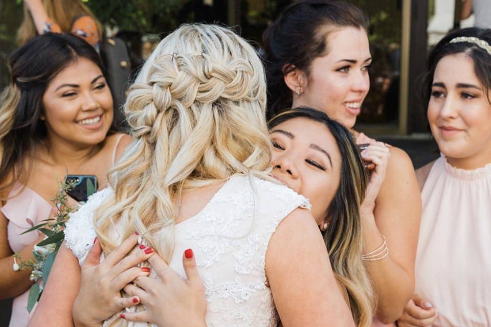 Bride embraces bridesmaid