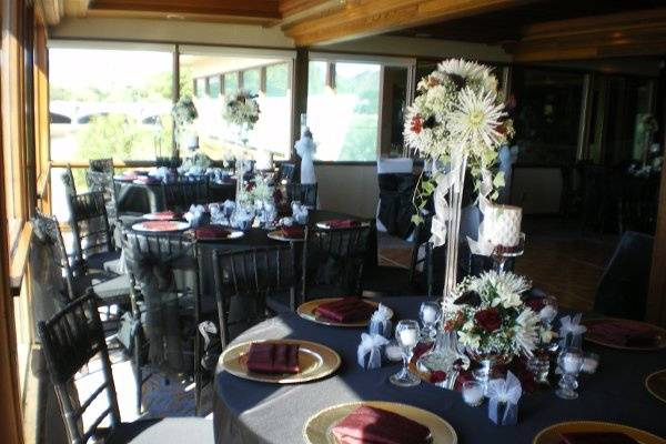 Multiple design centerpieces are enhanced by the sheen of black lamour linens and gold chargers