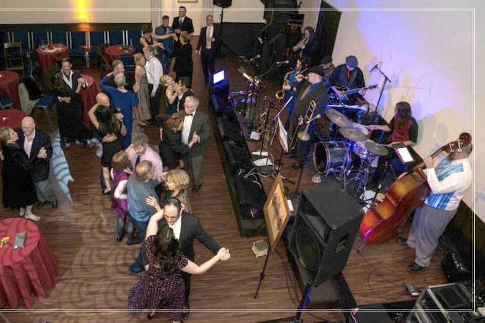 The Main Ballroom is a wonderful, large gathering space. Perfect for wedding Ceremonies, Receptions, Galas, lectures, presentations, play readings, workshops, and celebrations, this room can fit 125 for a cocktail reception or 106 seated guests (chairs and tables in picture shown). The room measures 39' X 39' and has 6 different entrances and exits. This marvelous hall features a wrap around balcony along three sides, a stage, a baby grand piano, and a projection wall (high-quality Epson projector available to rent for an additional fee).Located on our main floor, this room is completely ADA-accessible and ready for your event.