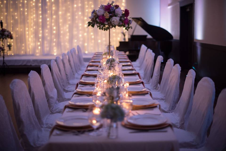 The Main Ballroom is a wonderful, large gathering space. Perfect for wedding Ceremonies, Receptions, Galas, lectures, presentations, play readings, workshops, and celebrations, this room can fit 125 for a cocktail reception or 100 seated guests (chairs and tables in picture shown). The room measures 39' X 39' and has 6 different entrances and exits. This marvelous hall features a wrap around balcony along three sides, a stage, a baby grand piano, and a projection wall (high-quality Epson projector available to rent for an additional fee).Located on our main floor, this room is completely ADA-accessible and ready for your event.