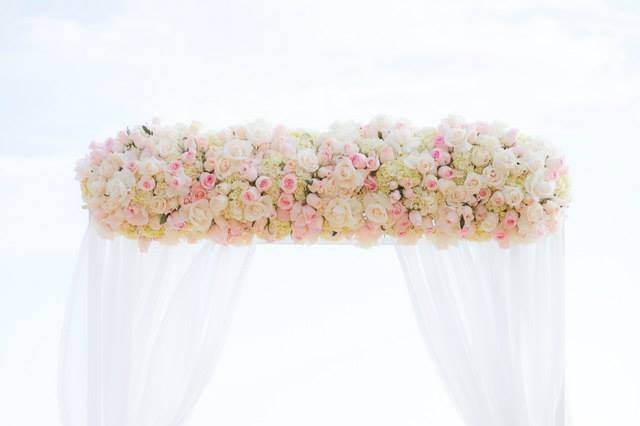 The breathtaking Catalina Terrace view at Surf and Sand Resort Laguna Beach.  White arbor draped with sheer white fabric, front piece designed with white hydrangea, blush and white roses.