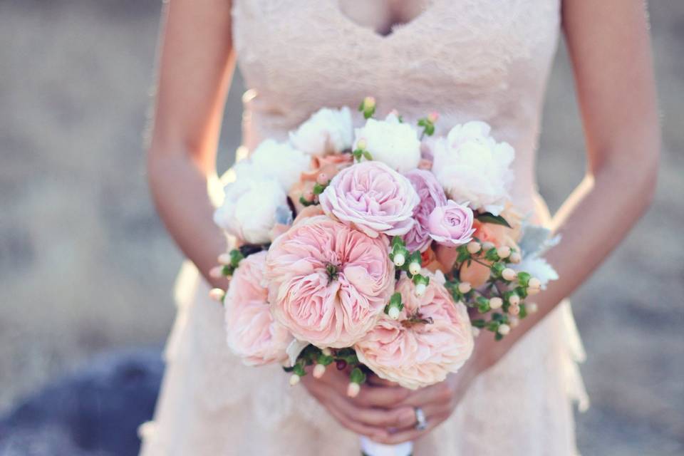 Elegant and lush for this backyard wedding, designed with peach garden roses, pink garden spray roses, peach roses, peach hypericum and white peonies.