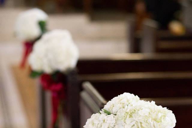 Simple and elegant pew bouquets.  White hydrangea and red bow