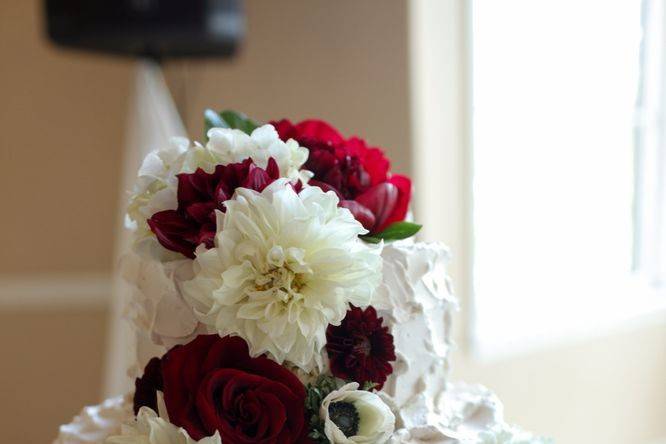 Tall and airy centerpiece designed with yellow and white lilies, white hydrangea, yellow roses, white snapdragons and white dendrobium orchids.