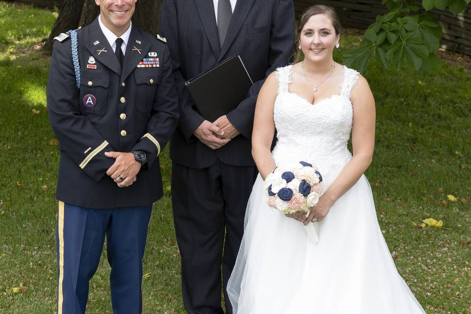 Newlywed couple with the officiant