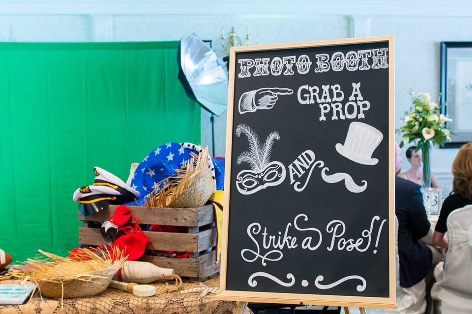 Booth sign, green screen, and props table