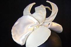 Orchid series couture fascinator,
White hair clips underneath secures this fascinator for a tight fit.
White shiny satin, ivory silky and pleather (front petal),
Mold to the head due to wiring within.
Prefect finish.