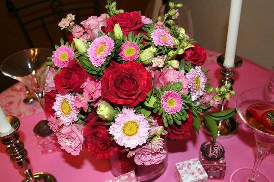 Romantic, fresh floral centerpiece in shades of red, pink, and green, designed by Something Floral.