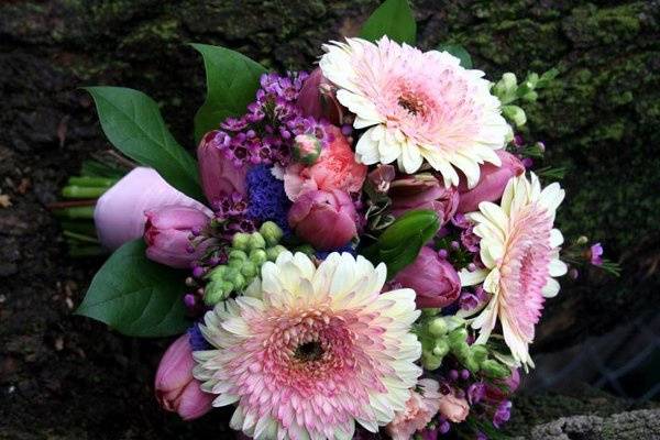 Garden-style, hand-tied bridal bouquet featuring fresh gerberas, tulips, and snapdragons, designed by Something Floral.