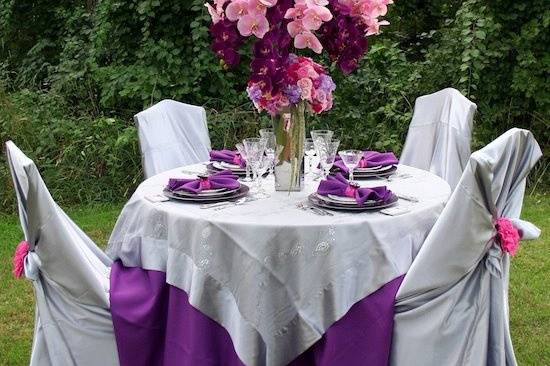 Combination fresh and artificial/silk/permanent floral reception table centerpiece of orchids and roses by Something Floral.