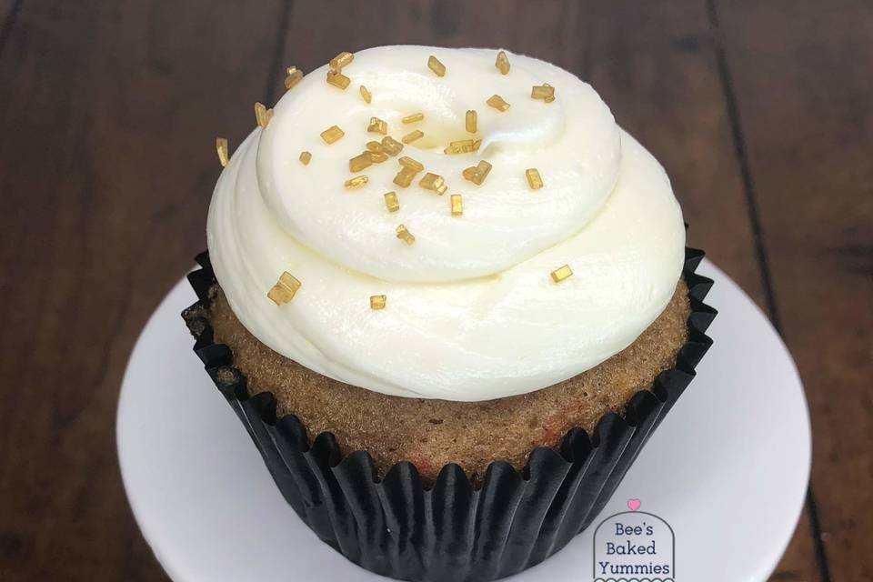 Delicious carrot cake cupcake with a crown of gold sprinkles