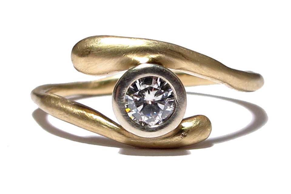 This yellow gold organically shaped band features a 3mm bezel set Moissanite. You can order this ring in white gold and can have a diamond instead of the Moissanite for an additional cost.